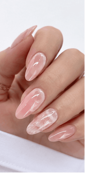 Almond nails are shaped with tapered sides and a softly rounded point, resembling the silhouette of an almond. This shape is loved for its elegant, feminine, and lengthening effect, making the fingers appear slimmer and more refined. Almond nails work best with medium to long nails, either natural or extended, because the tapered form needs enough length to balance the tip. They pair beautifully with French tips, chrome, cat-eye, aura, floral designs, pearls, marble, and bridal styles. Almond is a strong choice for clients who want sophistication, trend appeal, and a flattering hand shape without the sharpness of stiletto nails.