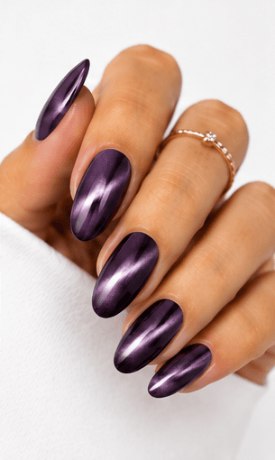 Cat-eye nails use magnetic gel to create a luminous line or velvet-like glow that shifts when the hands move. The effect resembles the reflective depth of a gemstone or a cat’s eye, giving the manicure a mysterious and elegant finish. This style is popular because it looks dimensional without needing complicated hand-painted art. It can be dramatic with dark jewel tones, romantic with pink and champagne shades, or soft and wearable with nude magnetic gels. Cat-eye nails are especially strong for salon photo collections because the light movement makes each angle look slightly different and luxurious.