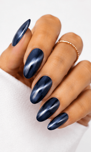 Cat-eye nails use magnetic gel to create a luminous line or velvet-like glow that shifts when the hands move. The effect resembles the reflective depth of a gemstone or a cat’s eye, giving the manicure a mysterious and elegant finish. This style is popular because it looks dimensional without needing complicated hand-painted art. It can be dramatic with dark jewel tones, romantic with pink and champagne shades, or soft and wearable with nude magnetic gels. Cat-eye nails are especially strong for salon photo collections because the light movement makes each angle look slightly different and luxurious.