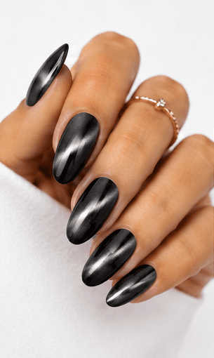 Cat-eye nails use magnetic gel to create a luminous line or velvet-like glow that shifts when the hands move. The effect resembles the reflective depth of a gemstone or a cat’s eye, giving the manicure a mysterious and elegant finish. This style is popular because it looks dimensional without needing complicated hand-painted art. It can be dramatic with dark jewel tones, romantic with pink and champagne shades, or soft and wearable with nude magnetic gels. Cat-eye nails are especially strong for salon photo collections because the light movement makes each angle look slightly different and luxurious.