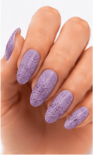 Emboss nails create raised patterns that look pressed, carved, or sculpted into the manicure surface. Unlike large 3D charms, emboss designs are usually more integrated with the nail and often appear as raised flowers, lace, shells, knit textures, monograms, ribbons, or ornamental lines. This style feels refined because the texture can be subtle while still adding depth and craftsmanship. White emboss over nude or milky bases looks bridal and elegant, while metallic or dark emboss can feel vintage, gothic, or fashion-forward. It is useful for luxury nail collections, wedding menus, winter knit designs, and close-up beauty photography.
