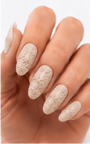 Emboss nails create raised patterns that look pressed, carved, or sculpted into the manicure surface. Unlike large 3D charms, emboss designs are usually more integrated with the nail and often appear as raised flowers, lace, shells, knit textures, monograms, ribbons, or ornamental lines. This style feels refined because the texture can be subtle while still adding depth and craftsmanship. White emboss over nude or milky bases looks bridal and elegant, while metallic or dark emboss can feel vintage, gothic, or fashion-forward. It is useful for luxury nail collections, wedding menus, winter knit designs, and close-up beauty photography.