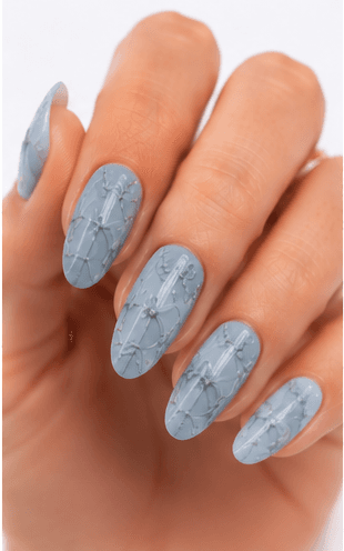 Emboss nails create raised patterns that look pressed, carved, or sculpted into the manicure surface. Unlike large 3D charms, emboss designs are usually more integrated with the nail and often appear as raised flowers, lace, shells, knit textures, monograms, ribbons, or ornamental lines. This style feels refined because the texture can be subtle while still adding depth and craftsmanship. White emboss over nude or milky bases looks bridal and elegant, while metallic or dark emboss can feel vintage, gothic, or fashion-forward. It is useful for luxury nail collections, wedding menus, winter knit designs, and close-up beauty photography.