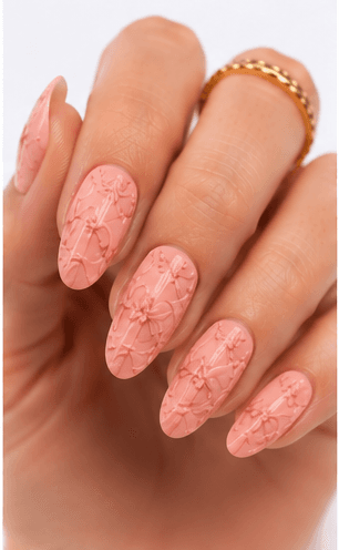 Emboss nails create raised patterns that look pressed, carved, or sculpted into the manicure surface. Unlike large 3D charms, emboss designs are usually more integrated with the nail and often appear as raised flowers, lace, shells, knit textures, monograms, ribbons, or ornamental lines. This style feels refined because the texture can be subtle while still adding depth and craftsmanship. White emboss over nude or milky bases looks bridal and elegant, while metallic or dark emboss can feel vintage, gothic, or fashion-forward. It is useful for luxury nail collections, wedding menus, winter knit designs, and close-up beauty photography.