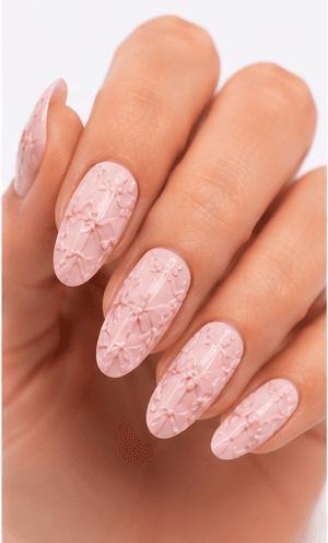 Emboss nails create raised patterns that look pressed, carved, or sculpted into the manicure surface. Unlike large 3D charms, emboss designs are usually more integrated with the nail and often appear as raised flowers, lace, shells, knit textures, monograms, ribbons, or ornamental lines. This style feels refined because the texture can be subtle while still adding depth and craftsmanship. White emboss over nude or milky bases looks bridal and elegant, while metallic or dark emboss can feel vintage, gothic, or fashion-forward. It is useful for luxury nail collections, wedding menus, winter knit designs, and close-up beauty photography.