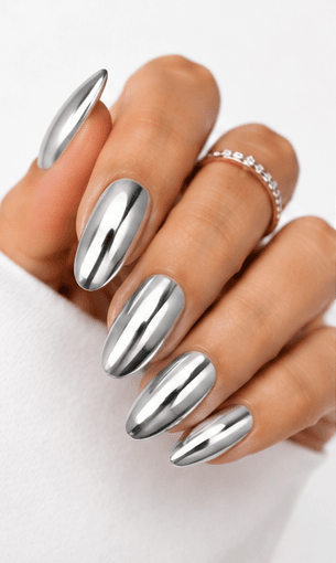 Mirror nails are known for their polished metallic reflection, creating a sleek, futuristic look that instantly catches the light. This style is often made with chrome powder or reflective gel layered over a smooth base color, giving the nails a glassy, high-shine finish. It works beautifully for minimalist fashion, luxury beauty shoots, party looks, and editorial nail collections. Depending on the base shade, mirror nails can feel cool and modern, glamorous and bold, or soft and elegant. They are especially popular among clients who want a statement manicure without heavy patterns or complicated art.